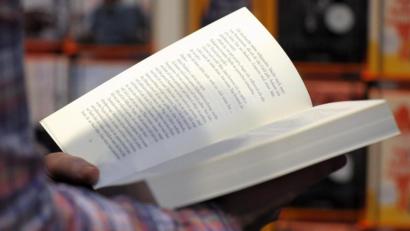 Symbolbild: Peter Endig
Eine Person hält ein aufgeschlagenes Buch in den Händen.