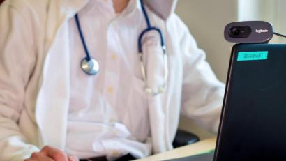 Bild: Monika Skolimowska
Ein Hausarzt sitzt während einer Videosprechstunde in seiner Praxis vor einem Laptop. Ein Team der Ostbayerischen Technischen Hochschule Amberg-Weiden (OTH) forscht, in welchen Bereichen die nächste Mobilfunkgeneration 5G die Gesundheitsversorgung in ländlichen Gegenden verbessern könnte.