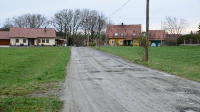 Bild: bey
Die Straße Am Mühlacker wird nicht vollausgebaut. Vielmehr werden zunächst nur die Löcher mit Schotter aufgefüllt. Nach der Fertigstellung eines Hauses auf einem Grundstück links der Straße wird der Straßenkörper aufgefräst und so verdichtet, dass das Niederschlagswasser beidseits ablaufen kann.