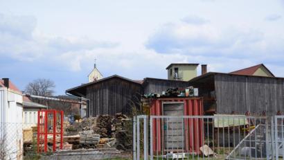 Bild: bey
Neben dem roten Container sollte der Sendemast der Deutschen Funkturm GmbH in Oberwildenau aufgestellt werden. Das Grundstück ist über die Maistraße erreichbar. Der Betonschleudermast mit seinem Gitteraufsatz hätte den Turm der St. Michaelskirche (im Hintergrund) überragt.