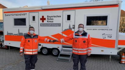 Bild: Franziska Rubenbauer/exb
Der bisherige Bereitschaftsleiter Wolfgang Potsch (links) übergibt die Dienststellungsabzeichen an den neuen Bereitschaftsleiter Nicolas Stoffregen (rechts). Im Hintergrund die aktuell als Teststation genutzte Sanitätsstation der Bereitschaft Amberg 1.