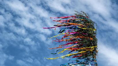 Bild: Federico Gambarini/dpa 
Bunte Bänder eines Maibaumes flattern vor dem blauen Himmel. Am 1. Mai ist normalerweise viel los. Aber wegen der Coronavirus-Pandemie sind die meisten traditionellen Feiern zum Beginn des Wonnemonats nicht möglich.