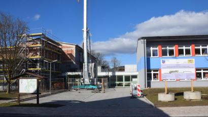 Bild: fz
Die Schule (rechts) wächst, die Sanierung der Mehrzweckhalle (links) schreitet voran. Dazwischen - und da steigen die Buchungszahlen - der Anbau für die Mittagsbetreuung.