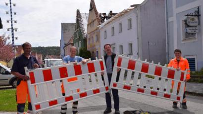 Bild: bö
Nach fast einem Jahr wird rechtzeitig zum Vatertag am Marktplatz in Hohenburg die Straßenabsperrung abgebaut. Damit ist auch die Umleitung des Verkehrs der Staatsstraße 2235 über die Vorplätze der Häuser passé. Bürgermeister Florian Junkes (Zweiter von rechts) räumt zusammen mit Bauhofmitarbeitern die Absperrung weg.