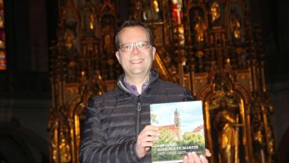 Bild: ads
Stadtpfarrer Thomas Helm mit der druckfrischen Jubiläumschronik St. Martin, die anlässlich des 600. Jahrestags der Grundsteinlegung der Martinskirche aufgelegt wurde.