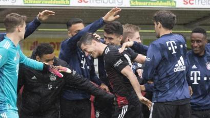 Bild: Tom Weller
Robert Lewandowski (Mitte) holt sich die Glückwünsche seiner Mannschaftskollegen ab. Mit seinem Elfmetertor in der Partie beim SC Freiburg egalisierte der Bayern-Torjäger den in der Spielzeit 1971/72 von Gerd Müller aufgestellten Bundesliga-Rekord von 40 Toren in einer Saison.