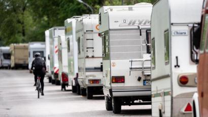 Archivbild: Matthias Balk/dpa
Ein Radfahrer fährt in einer Straße an geparkten Wohnmobilen vorbei.