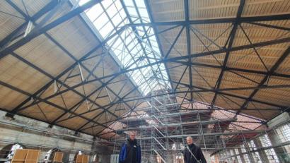 Bild: Peggy Biczysko/fph
Projektleiter Alexander Rieß (links) und Architekt Uwe Gebhard vom Büro Kuchenreuther sind begeistert davon, wie sich die Halle im ersten Drittel, das bereits saniert ist, präsentiert. Die Holzdecke bleibt sichtbar, ebenso die metallenen Verstrebungen, die frisch überarbeitet worden sind.