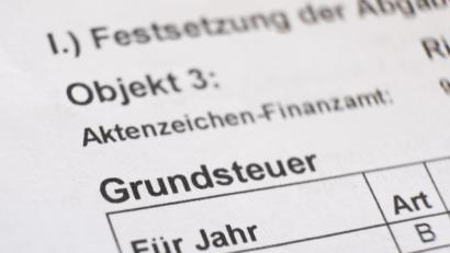 Bild: Bernd Weissbrod/dpa
Ein Bescheid über die Grundsteuer liegt auf einem Schreibtisch.