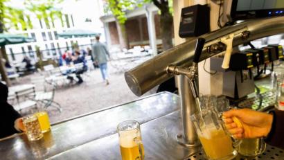 Bild: Philipp von Ditfurth/picture alliance/dpa
Die Thekenkraft eines Biergartens zapft ein Bier, während im Hintergrund Gäste und Personal des Biergartens zu sehen sind.