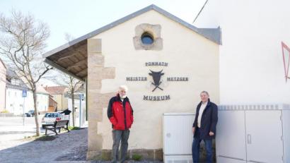 Bild: kaz
"Ponnath Meister Metzger Museum" steht seit kurzem an der Hauswand der ehemaligen Fleischbank. In der Mitte ist ein Ochsenkopf mit zwei Beilen zu sehen. Der ehemalige Firmenschild-Ausleger stammt von Metzgermeister Alois Bayer (rechts). Seit 20 Jahren ist das Fleischbankl bereits ein Museum. Auf Anfrage führt Hans Rösch durch das Fleischbankl.