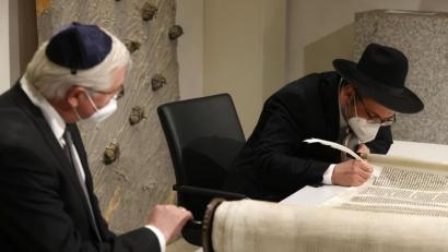 Archivbild: Odd Andersen/dpa
Rabbiner Shaul Nekrich (rechts) vollendet beim Holocaust-Gedenken am 27. Januar in Berlin die restaurierte Sulzbacher Torarolle von 1793. Bei der Zeremonie im Andachtsraum des Bundestags stehen die höchsten Repräsentanten der BRD Pate für die letzten Buchstaben der Schriftenrolle, so auch Bundespräsident Frank-Walter Steinmeier (links).