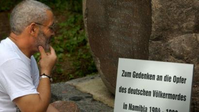 Bild: Stephanie Pilick/dpa
Israel Kaunatjike, Angehöriger des Herero-Volkes, betrachtet auf dem Garnisonfriedhof in Berlin eine Gedenktafel für die "Opfer des deutschen Völkermordes in Namibia von 1904 bis 1908". 2004 begann mit der Schlacht am Waterberg zwischen deutschen "Schutztruppen" und den Hereo im früheren Deutsch-Südwestafrika ein Krieg, bei dem zehntausende Hereo verdursteten; die "Schutztruppen" blockierten die wenigen Wasserstellen. Die Tafel wurde vom Trägerkreis - "Erinnern - Deutsche Kolonialgeschichte aufarbeiten" an den Gedenkstein gelehnt, der bislang nur an die in Namibia gefallenen deutschen Soldaten erinnert.