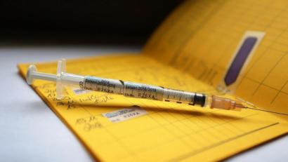 Symbolbild: Karl-Josef Hildenbrand
Eine Spritze, die mit dem Namen eines Grippeimpfstoffs gekennzeichnet ist, liegt auf einem Impfpass.