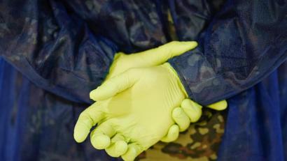 Bild: Uwe Anspach
Ein Soldat der Bundeswehr trägt an den auf dem Rücken verschränkten Händen grüne Gummihandschuhe. Im Rahmen des Freiwilligen-Netzwerks «Helfende Hände» organisiert die Bundeswehr schnelle Hilfe in Alten- und Pflegeeinrichtungen.