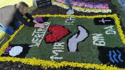 Bild: gz
Ein Blumenteppich als besondere Handschrift für Fronleichnam in Corona-Zeiten. Manuela Klug legt in Eslarn die letzten Buchstaben.