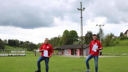 Bild: lei
Sportlicher Leiter Stefan Pirner (links) und Kassier Jürgen Leißner (rechts) halten die Förderbescheide für das neue Flutlicht in den Händen. Damit haben die alten Halogenstrahler (im Hintergrund) bald ausgedient.