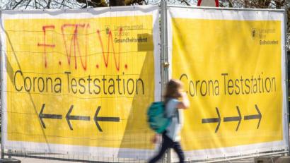 Bild: Peter Kneffel/dpa
Große gelbe Banner mit der Aufschrift „Corona Teststation“ hängen an Absperrgittern an der Theresienwiese in München.