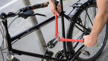 Symbolbild: Andreas Gebert/dpa
Ein Mann versucht mit einem Bolzenschneider ein Fahrradschloss aufzubrechen.