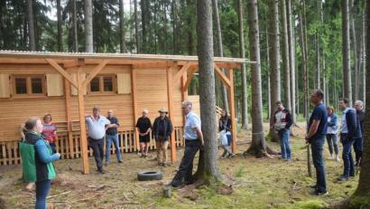 Bild: fz
Sabrina Schwab (links) von LearningCampus informiert die Etzenrichter Gemeindevertreter mit Bürgermeister Martin Schregelmann (dritter von links) zusammen mit Irchenrieths Bürgermeister Josef Hammer (Mitte am Baum stehend) über Entstehung und Betrieb des Waldkindergartens, der die Etzenrichter beeindruckte.