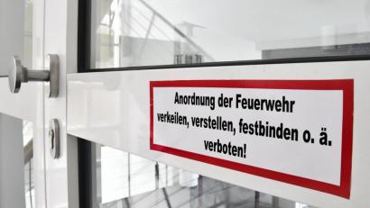 Bild: Petra Hartl
Ein Hinweis auf einer Rauchschutztür erinnert daran: Solche Türen müssen im Ernstfall Bereiche eines Gebäudes automatisch abriegeln, deshalb darf man sie nicht offen halten.