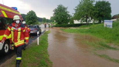 Bild: Fabian Schildbach/exb
Eine Flutwelle aus schlammigem Wasser läuft im Ort Eigentshofen von einer abschüssigen Wiese ab und setzt ein Haus unter Wasser. Beim Einsatz bereitet der Feuerwehr Hohenkemnath ein technischer Defekt an ihrem Einsatzfahrzeug Probleme.