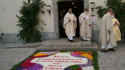 Bild: fpoz
Blickfang vor der alten Kirche Sankt Sebastian: ein Blumenteppich mit dem Primizspruch des Jubelpfarrers Thomas Strunz (links). Mit ihm freuten sich (von links) der Waldershofer Stadtpfarrer Bernd Philipp, Dekan Josef Geismar und Pfarrer Sven Grillmeier.