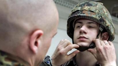 Archivbild: Frank May
Ein Bundeswehrsoldat hilft im April 2005 einem gerade eingezogenen Kameraden den Helm aufzusetzen.