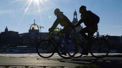 Archivbild: Robert Michael/dpa
Radfahrer auf dem Elberadweg am Königsufer gegenüber der Dresdner Altstadt mit der Kuppel der Kunstakademie (links) und der Frauenkirche.
