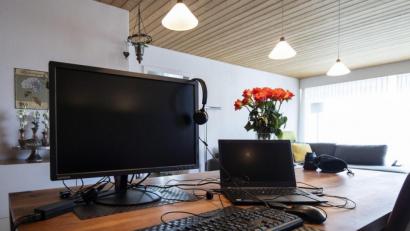Symbolbild: Peter Schneider/dpa
Ein Laptop, Bildschirm und Kopfhörer liegen für die Arbeit im Home Office bereit.