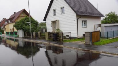 Bild: bkr
Aus zwei Kanaldeckeln sprudelt bei Starkregen „Material“ und schwappt über die niedrige Bordsteinkante auf die Grundstücke.