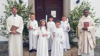 Bild: ld
Fünf Kinder gingen in diesem Jahr zum ersten Mal zum Tisch des Herrn. Pater Joy (rechts) und Pastoralreferent Maximilian Pravida hatten sie auf den großen Tag vorbereitet.