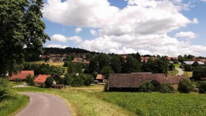 Bild: Portner
Die Ortschaft Fuchsberg mit Bubenlohe (unten), dem Ortskern (mittig hinter den Bäumen) sowie der gewachsenen Siedlung schmiegt sich an einen Südhang zwischen Teunz und Kühried.