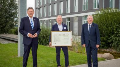 Bild: Fotografie Pokorny/exb	
HWK-Präsident Dr. Georg Haber (links) überreicht zusammen mit HWK-Hauptgeschäftsführer Jürgen Kilger (rechts) im Rahmen der Vollversammlung den Goldenen Meisterbrief an Gas- und Wasserinstallateurmeister Josef Schmucker.