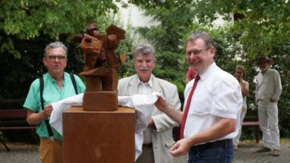 Bild: weu
Stellvertretender Landrat Jakob Scharf (Mitte) und Bürgermeister Martin Prey (rechts) enthüllten gemeinsam mit dem Künstler Heiko Herrmann die Skulptur "Trag mich ein Stück". Diese hat der Kunstverein der Gemeinde als Geschenk gemacht. Es soll ein Symbol für gelebte Dorfgemeinschaft sein.