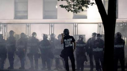 Bild: Morry Gash/AP/dpa
Black Lives Matter – schwarze Leben zählen, schwarze Leben sind wichtig – steht auf dem T-Shirt dieses Demonstranten in Kenosha, USA. Er hat sich vor Polizisten postiert. Mehrere Schüsse in den Rücken des schwarzen Amerikaners Jacob Blake bei einem Polizeieinsatz im US-Bundesstaat Wisconsin haben Entsetzen und Proteste ausgelöst.