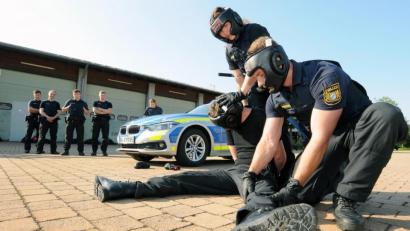 Bild: Stephan Huber
Übung macht den Meister: Diese Verkehrskontrolle ist eskaliert, doch die Polizeischüler haben die Angreiferin unter dem strengen Blick der Ausbilder mit geübten Griffen zu Boden gebracht. Die restlichen Polizeianwärter im Hintergrund schauen aufmerksam zu.