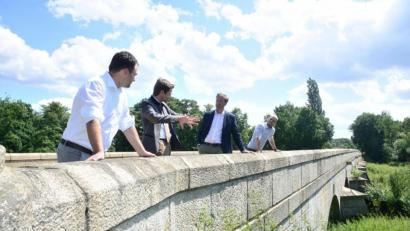 Bild: bey
Bürgermeister Sebastian Hartl und Abgeordneter Stephan Oetzinger erörtern mit Baudirektor Tobias Bäumler und Baurat Felix Steghöfer (von links) den Umfang der notwendig werdenden Sanierung der steinernen Brücke über die Waldnaab oberhalb von Unterwildenau. Dazu gehörte auch ein Blick ins malerische Flussbett der Waldnaab.