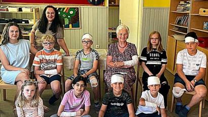 Bild: R. Kreuzer
AWO-Vorsitzende Hilde Zebisch (sitzend, Dritte von rechts) ist auch verletzt und wurde von Kindern fachgerecht verarztet.