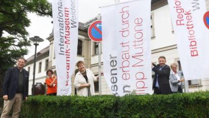 Bild: Gabi Schönberger
(Von links) Konstantin Thomas (Die Keramischen), Stefanie Dietz (Museumsleiterin), Petra Vorsatz (Stadtarchiv), Oberbürgermeister Jens Meyer und Sabine Guhl (Leiterin Regionalbibliothek) hissen die Fahnen vor dem Keramikmuseum in Weiden.
