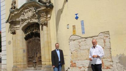 Bild: ads
Stadtpfarrer Thomas Helm und Kirchenpfleger Josef Beer (von links) von St. Martin machen sich ein Bild von den baulichen Schäden im Sockelbereich der Schulkirche. Die Sanierungsarbeiten sind dieser Tage angelaufen.