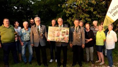 Bild: sck
Der neue Schützenmeister von 1890 Auerbach, Wolfgang Ziebell (Mitte), hält eine Collage mit bildlich festgehaltenen Höhepunkten aus der Amtszeit seines Vorgängers in den Händen, die Dietmar Neugebauer bei nächster Gelegenheit überreicht bekommt. Mit im Bild die Führungsmannschaft des Vereins.