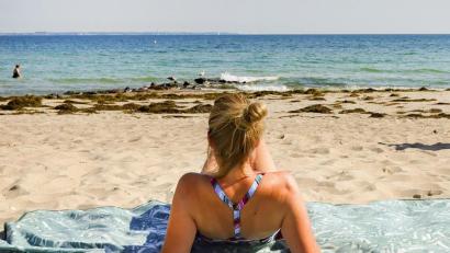 Symbolbild: Ulrich Perrey/dpa
Eine Urlauberin genießt das sommerliche Wetter am Ostseeufer in Timmendorfer Strand.