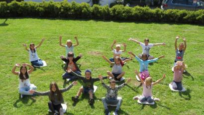 Bild: adj
Geschafft. Nach dem Anfertigen der Tonplastiken entspannen die Kinder auf der Wiese und strecken ihre Arme wie Fühler nach oben.