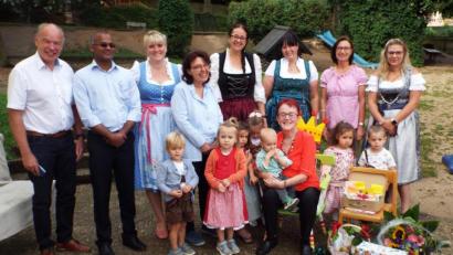 Bild: e
Kinderpflegerin Maria Lautenschlager (sitzend inmitten ihrer Kinder) wird verabschiedet von (von links) Bürgermeister Strehl, P. Sainat Thomas Arokiasamy und Christine Schmeiler sowie Leiterin Nadine Rall (Dritte von rechts).
