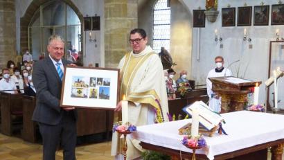 Bild: müb
Während der Festmesse zum Patrozinium St. Mariä Himmelfahrt überreicht Pfarrgemeinderatsvorsitzender Richard Reisinger eine Fotocollage an Pfarrer Walter Hellauer.