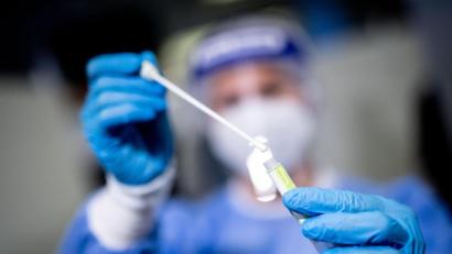 Symbolbild: Matthias Balk/dpa
Eine Mitarbeiterin hält in einem Covid-19-Testcenter die Probe von einem Rachenabstrich in den Händen.