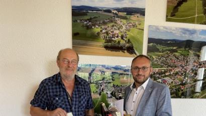 Bild: fjo
Vor den neuen Luftaufnahmen im Bürgermeisterzimmer des Rathauses überreicht Markus Bauriedl an Hermann Schmidt (links) sinngebend die Auszeichnung des bayerischen Finanz- und Heimatministeriums.