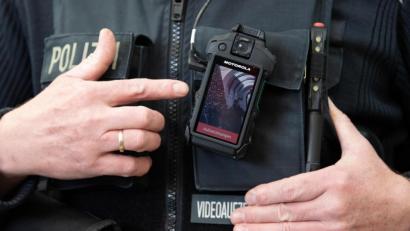 Bild: Sebastian Kahnert/dpa
Ein Polizeikommissar erklärt die Funktionsweise einer Bodycam. Mit einer solchen Kamera wurde die Beleidigungs-Tirade einer 54-Jährigen gegenüber mehreren Polizisten am Bahnhof Schwandorf aufgezeichnet.