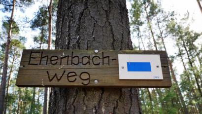 Bild: ind
Ein Schild weist auf den neuen Ehenbach-Weg hin – markiert ist er mit einem blauen Querbalken auf einem weißen Rechteck.